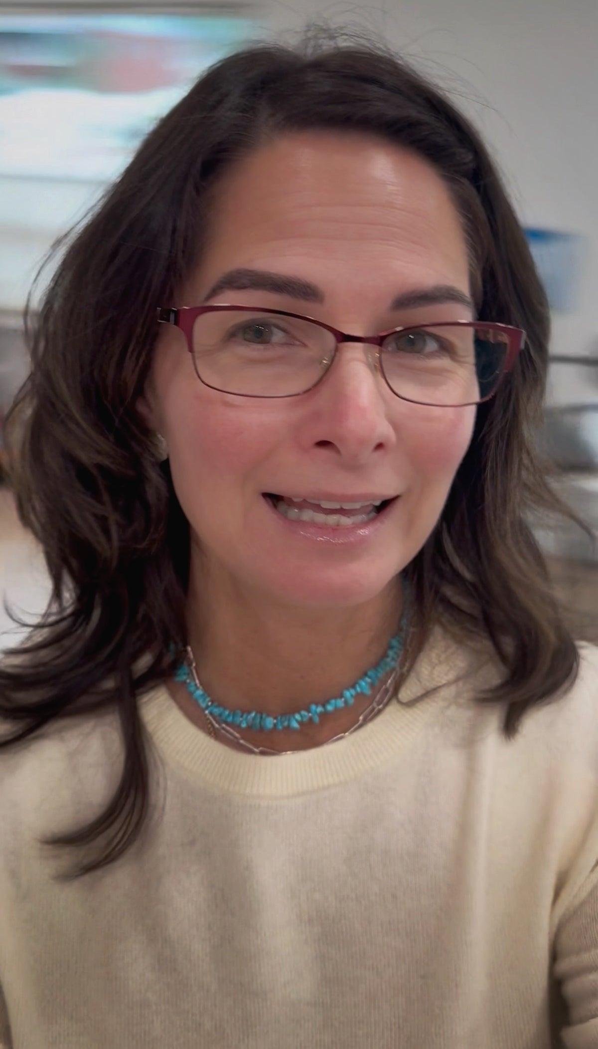 Necklace down in Kelly, the artist, wearing a buttery yellow sweater